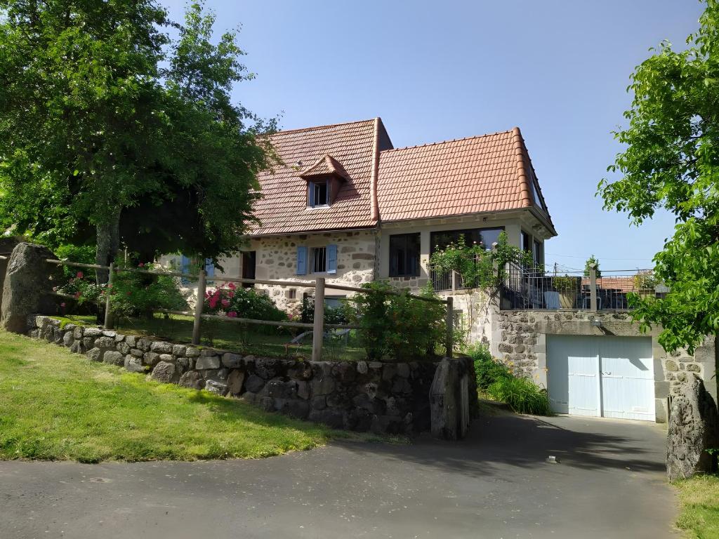 a stone house with a gate and a stone wall at Gîte de Pradevin in Jou-sous-Monjou
