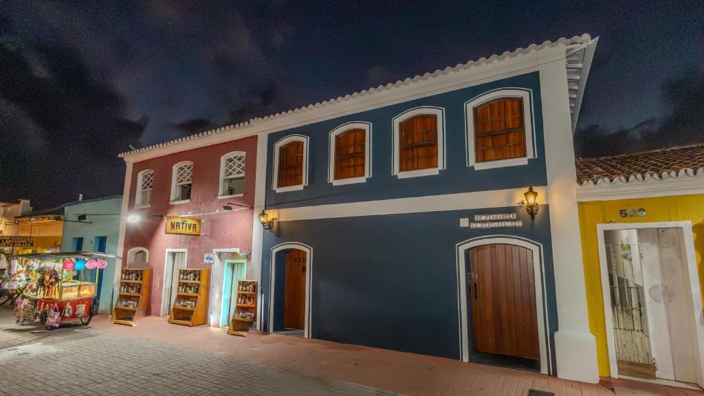 a blue building with windows on a street at night at Ap Passarela in Porto Seguro