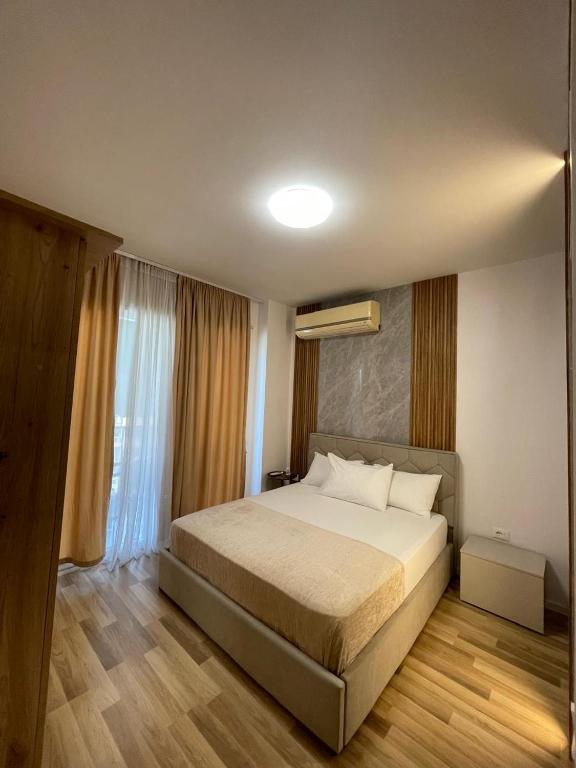 a bedroom with a large bed and a window at Enea Apartments 8 in Tirana