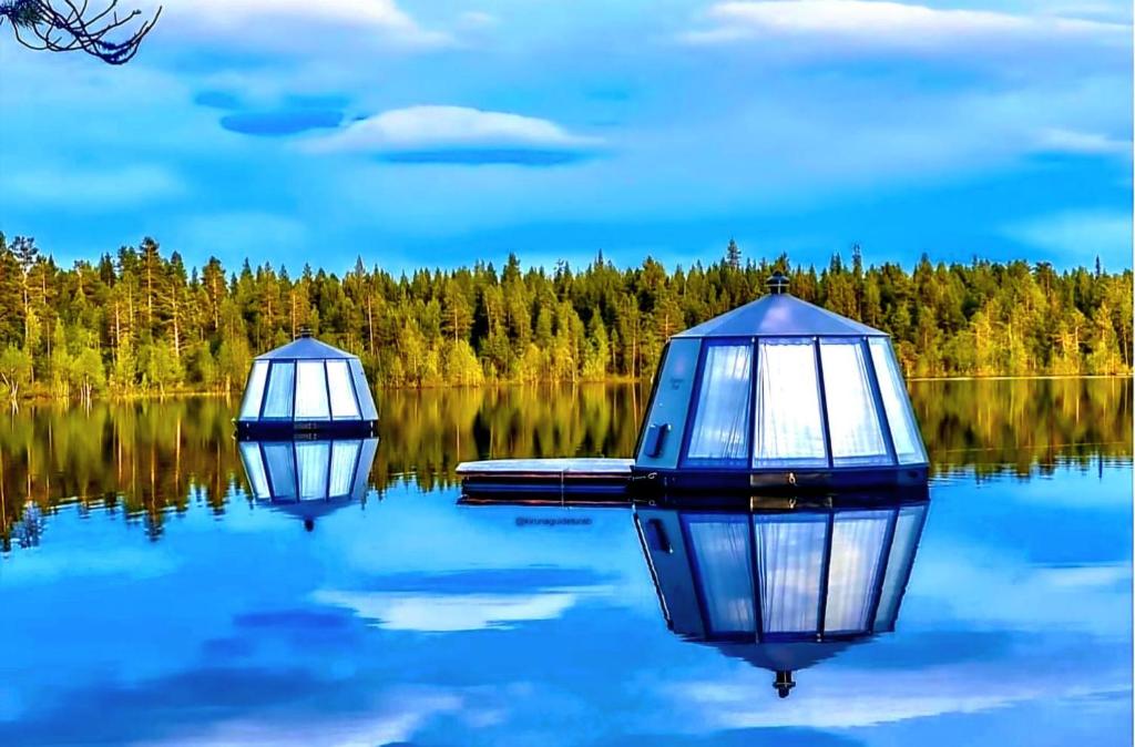 two boats on a lake with trees in the background at Aurora Camp Kiruna in Kiruna