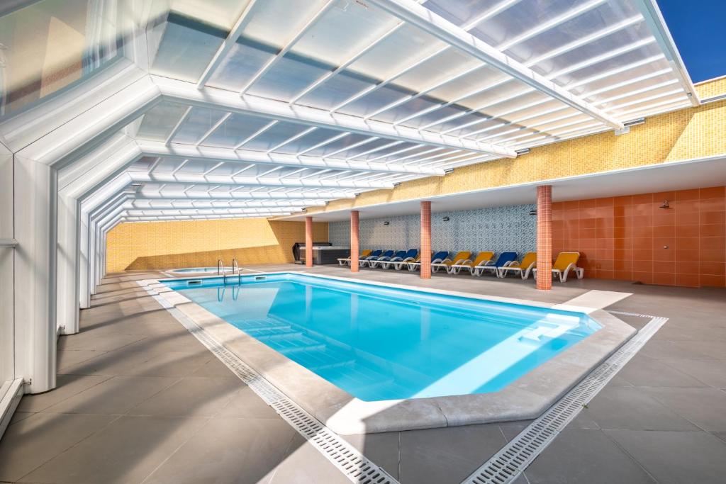 a large swimming pool in a building at Hotel Colmeia in Monte Real