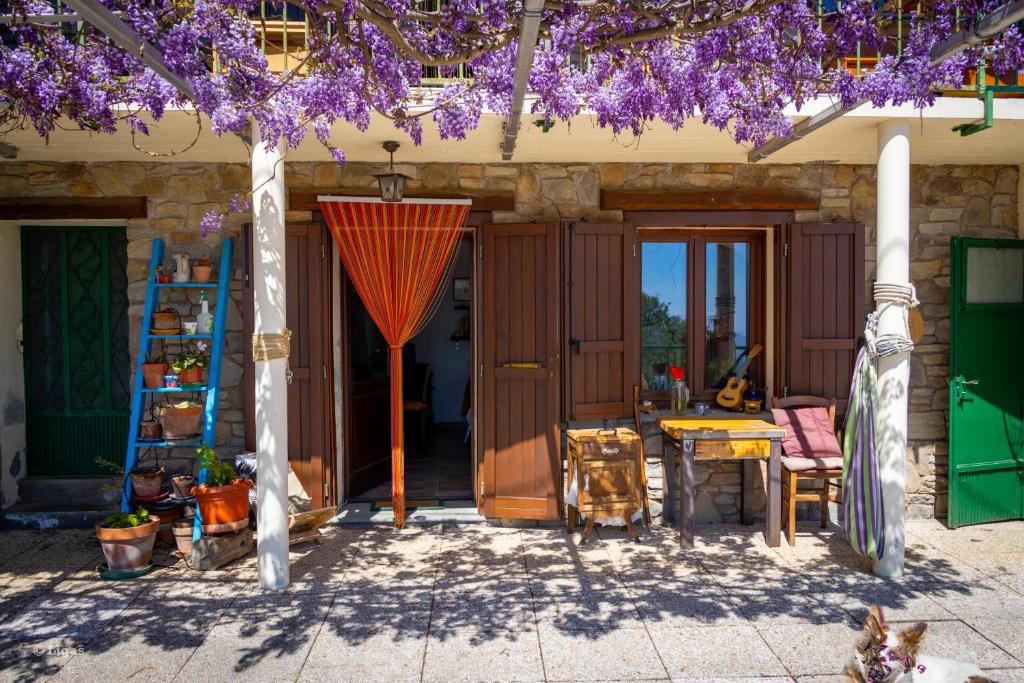 a patio with purple flowers and a table and chairs at Borgata Giostra in Caprie
