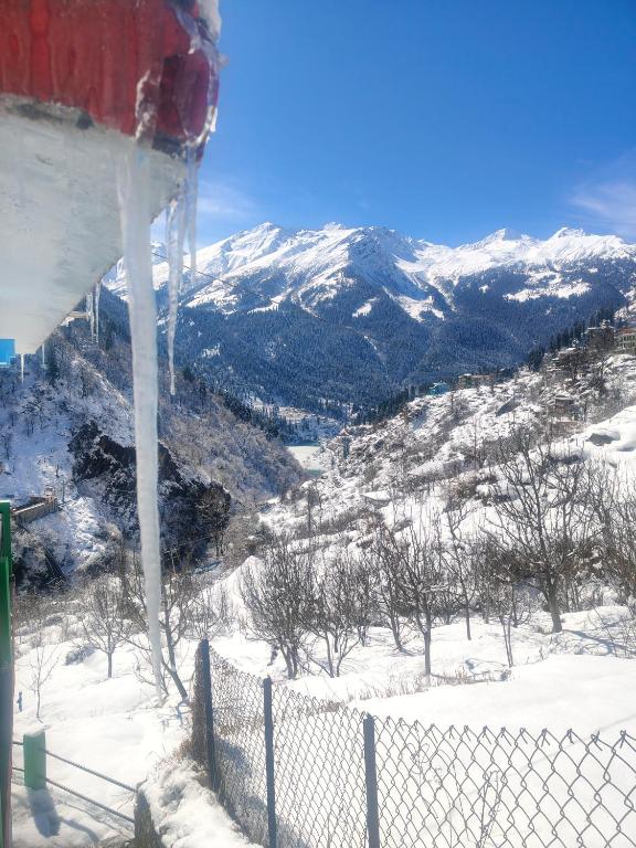 a snow covered mountain with a fence in the foreground at sanoview in Kulu