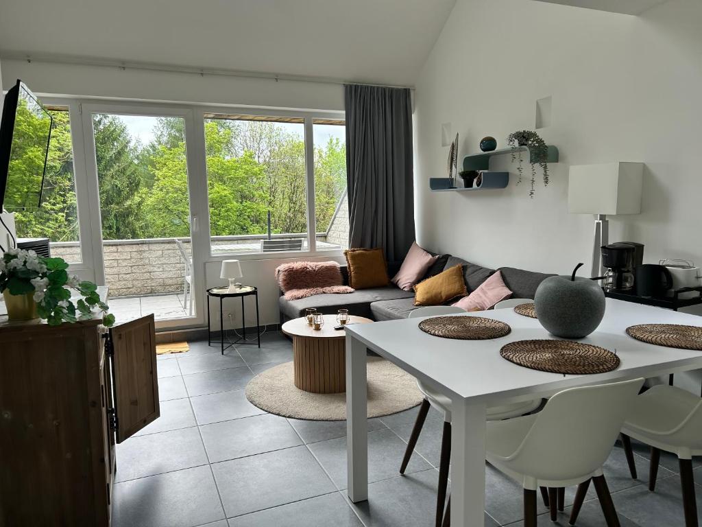 a living room with a couch and a table at Les terrasses de Malmedy duplex 420 in Malmedy