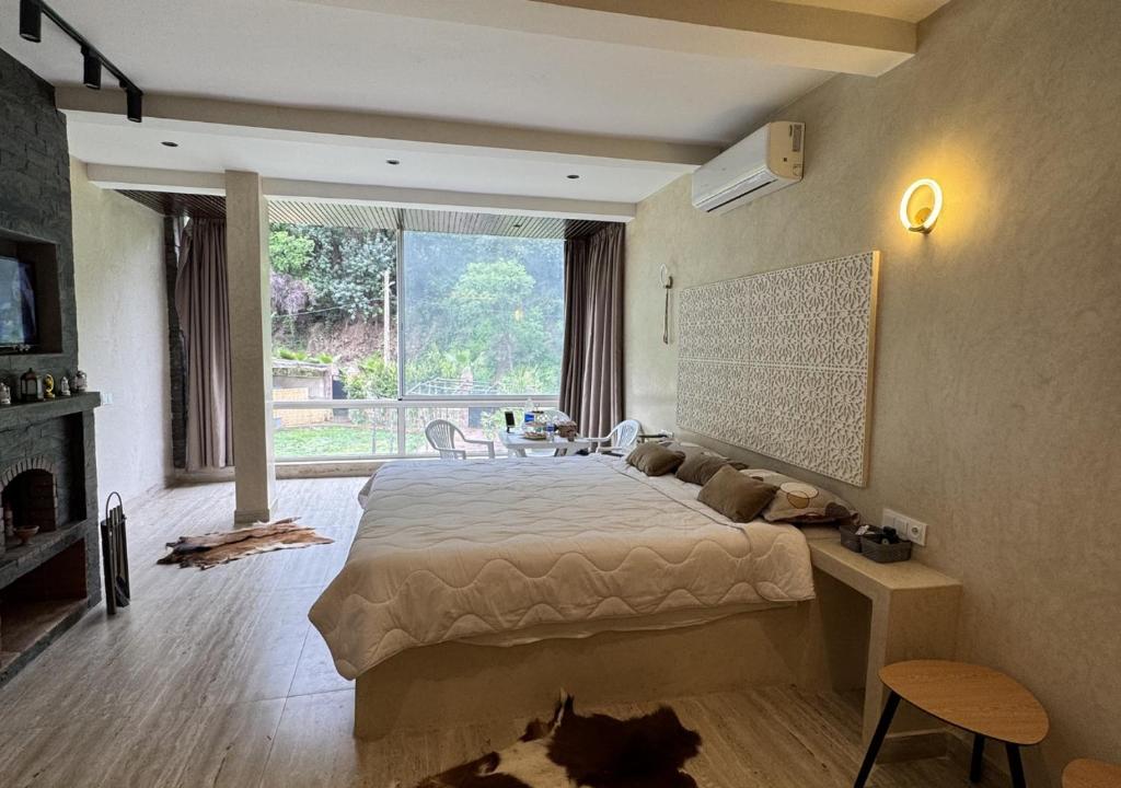 una camera da letto con un grande letto e una grande finestra di Hotel Asael a Ourika