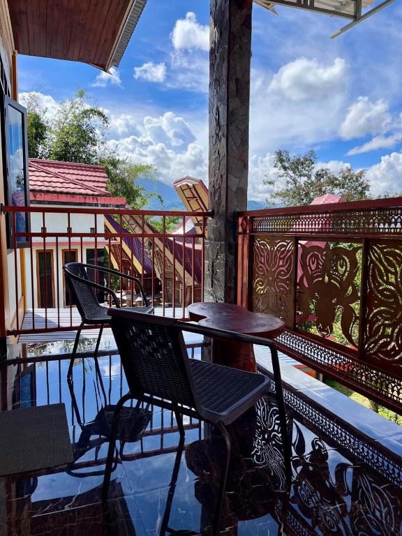 a patio with tables and chairs on a balcony at Toraja Bungin Family House in Rantepao