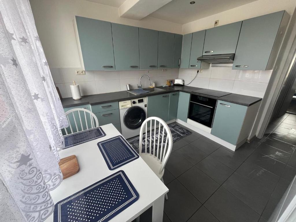 a kitchen with blue cabinets and a table and chairs at PINKY SQUARE apartman in Zvolen