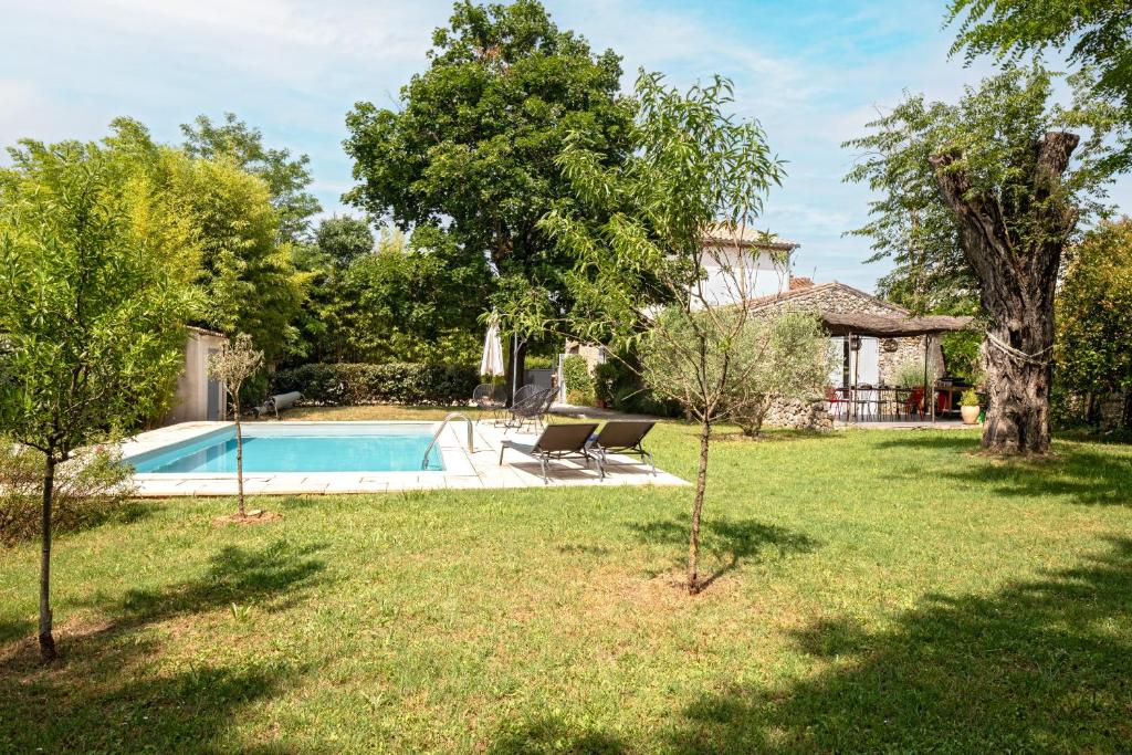 a backyard with a swimming pool and trees at Villa spacieuse avec piscine privée in Saint-Bauzille-de-Putois