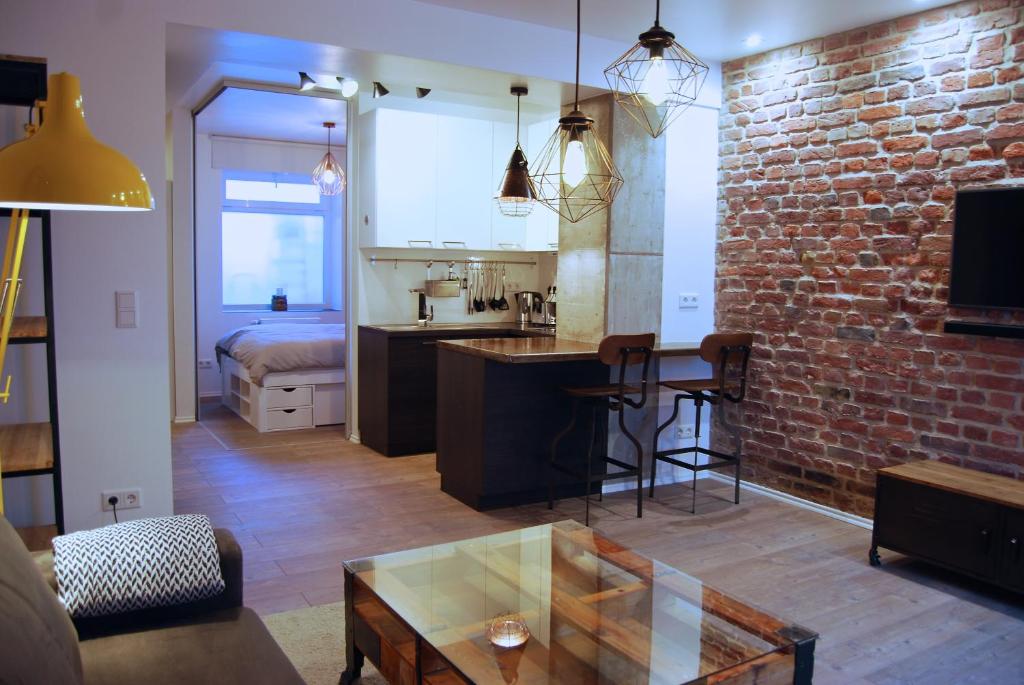 cocina y sala de estar con pared de ladrillo en Jordan Suite Executive Furnished Apartment, en Düsseldorf