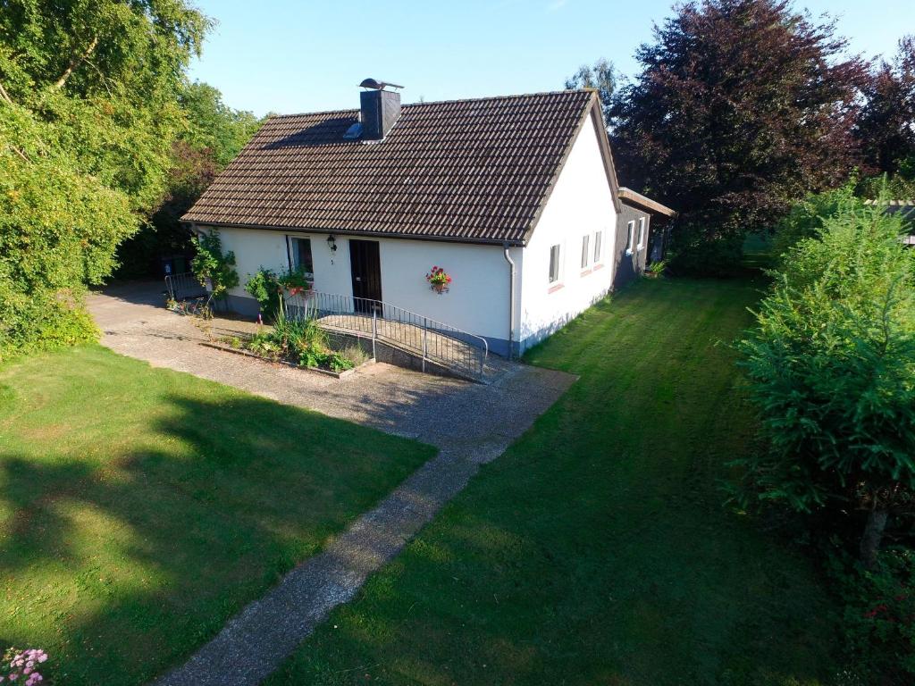 a small white house with a grass yard at Ferienhaus Schlei in Rabenkirchen-Faulück