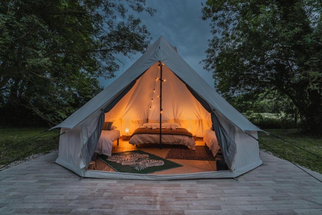 a white tent with a bed in it at Campement Ô Rêves in Genouilleux