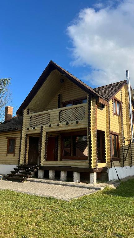 a large wooden house with a porch and grass at Наше Місце in Krymno