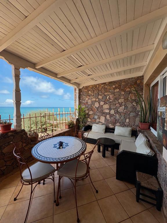 a patio with a table and chairs and a view of the ocean at Appartement terrasse de la mer in Mirleft