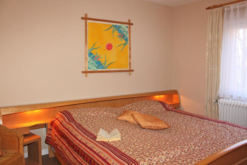 a bedroom with a bed with a book on it at Haus Hahn in Suhlendorf