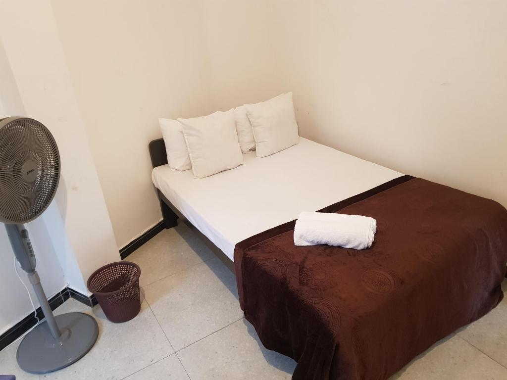 a small bedroom with a bed and a fan at Shalom View Homestay in Kandy
