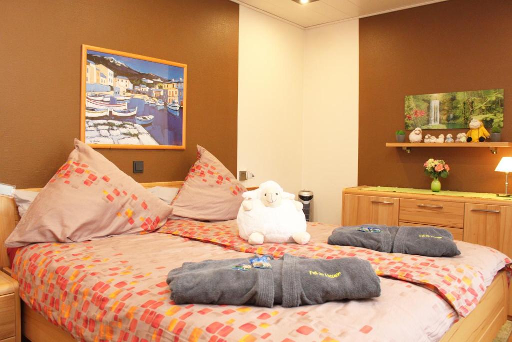a bed with two pillows and a teddy bear on it at Ferienwohnung Heuer in Ebstorf