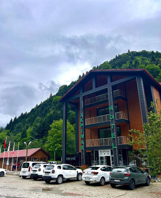 a large building with cars parked in a parking lot at Akpinar Hotel in Uzungöl