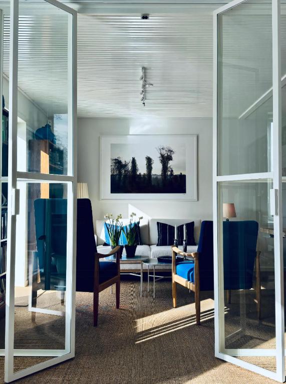 a living room with blue chairs and a table at Skagen Beach House in Ålbæk