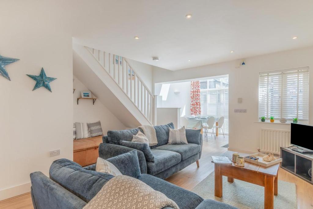 a living room with two blue couches and a staircase at 3 Bed in Chathill oc-61892 in Beadnell