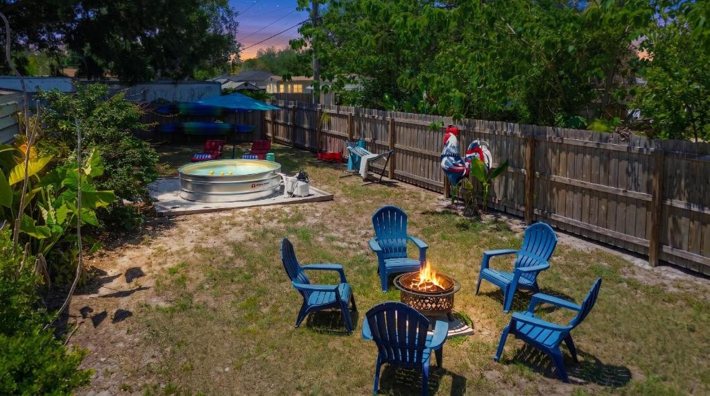 a group of chairs and a fire pit in a yard at Spacious 4 bedroom 3 bath Clearwater Vacation House Cowboy Pool Fire Pit Games Close to Clearwater Beach Biking Trail Farmers Markets Harbor Health Spa Baycare Ballpark and Ruth Eckerd Hall Golf Courses in Clearwater