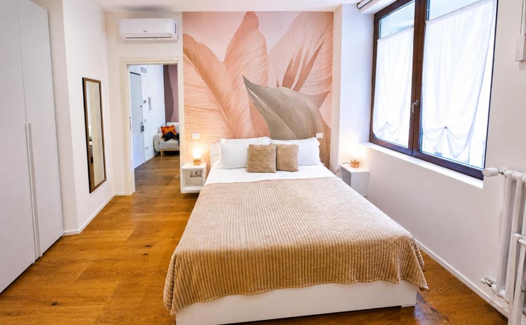 a bedroom with a bed and a large window at NS Urban Suite in Udine