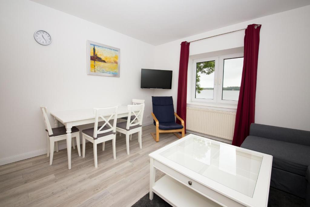 a living room with a table and a dining room at Schleiblick App 4 in Rabenkirchen-Faulück