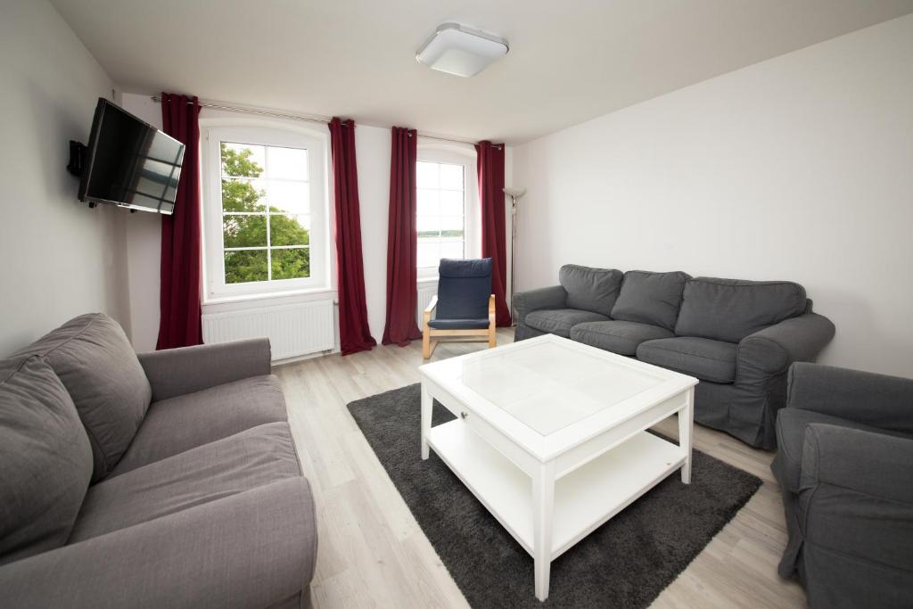a living room with a couch and a table at Schleiblick Familienappartement 13 in Rabenkirchen-Faulück