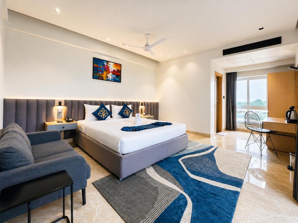 ein Schlafzimmer mit einem Kingsize-Bett und einer Couch in der Unterkunft Hotel Kyzen - Hitec city, Hyderabad in Hyderabad