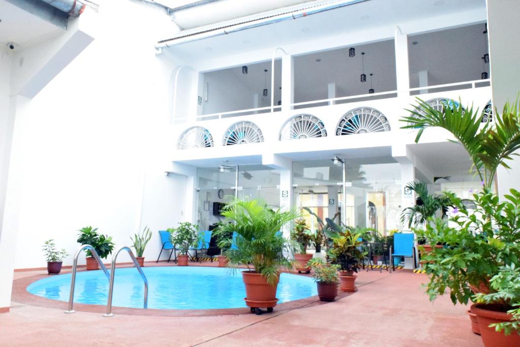 a large building with a pool and potted plants at Hotel Jungle House in Iquitos