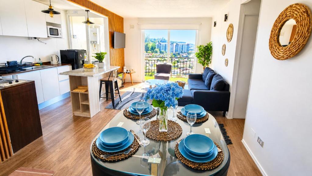 a living room with a table with blue dishes on it at Acogedor departamento céntrico vista al lago in Villarrica