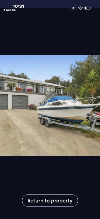 a boat is parked in front of a house at La Barca in Rye