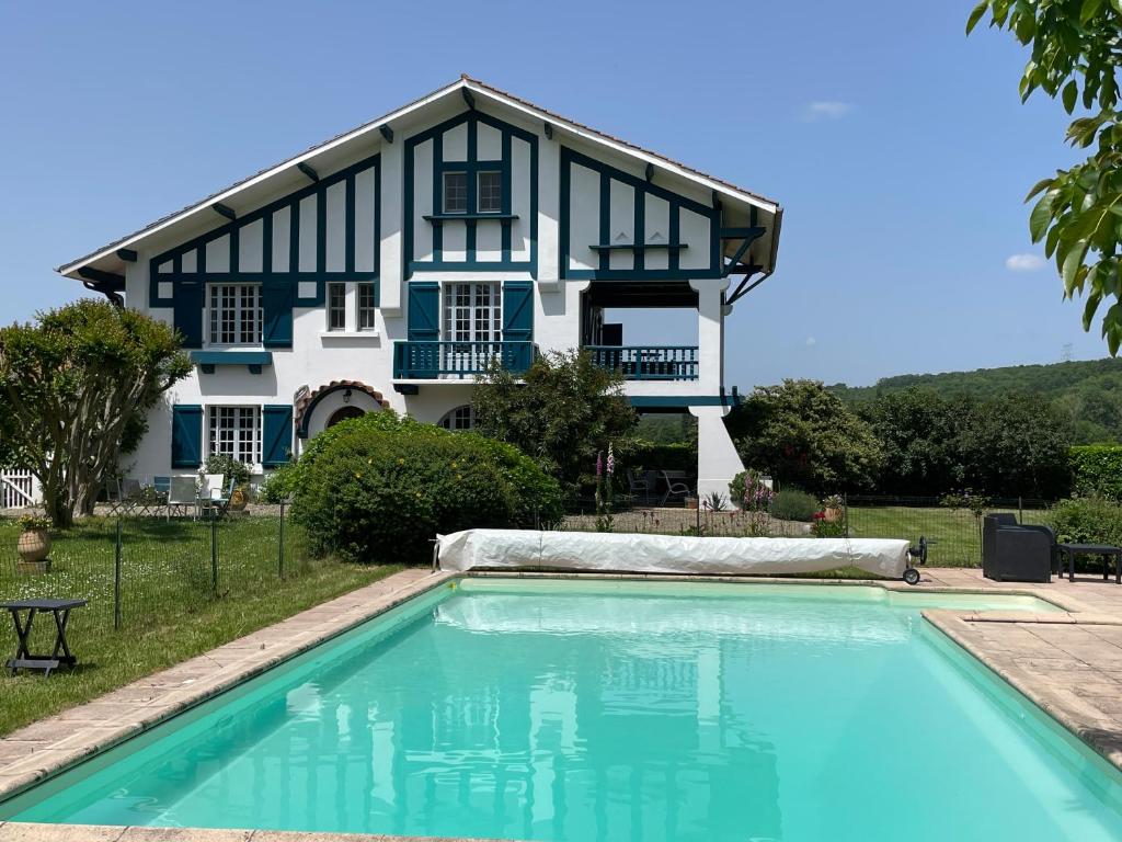 a house with a swimming pool in front of a house at Saint Sever des Pyrenees in Saint-Sever-de-Rustan