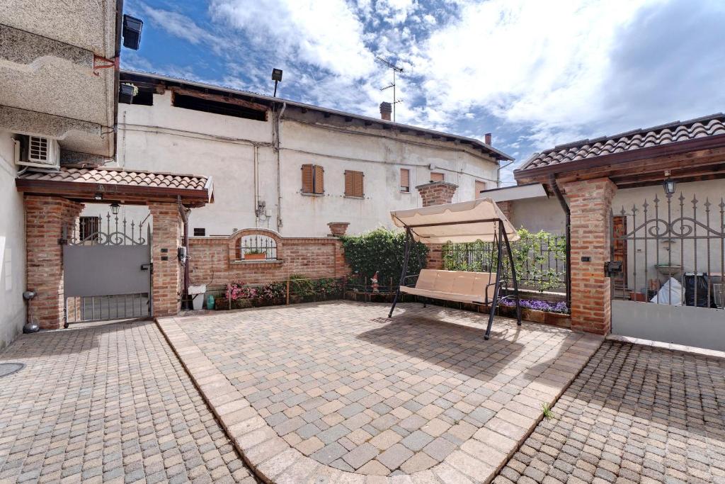 a courtyard with a fence and a building at Centenario Affittacamere in Fara Novarese