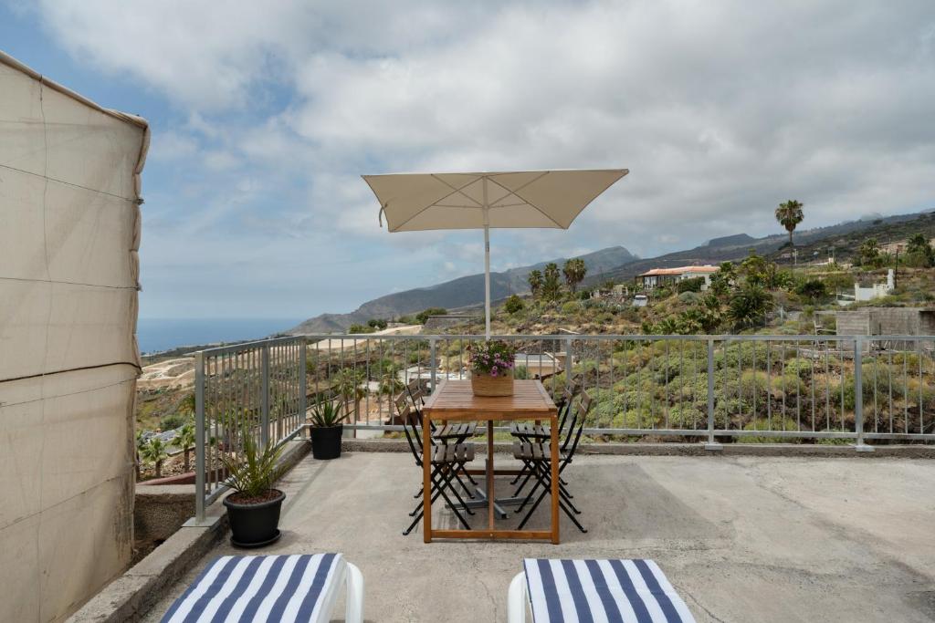 a table and chairs with an umbrella on a balcony at El Barril in Chio