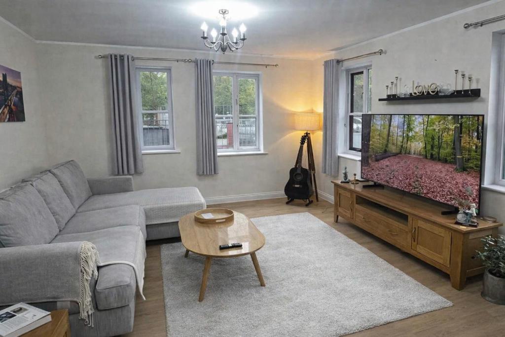 a living room with a couch and a flat screen tv at 2 Bedroom Flat in Manchester