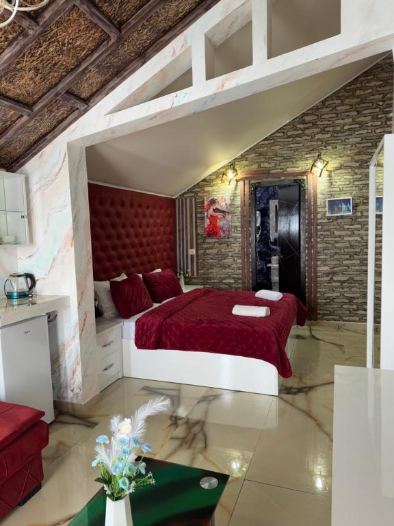 a bedroom with a red bed and a brick wall at Hotel City Building2 in Zugdidi
