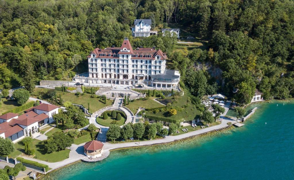 an aerial view of a large building on an island in the water at Le Palace de Menthon in Menthon-Saint-Bernard