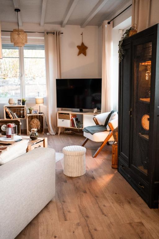 a living room with a couch and a tv at La bohème Langogne in Langogne