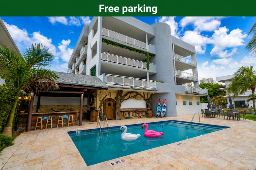 a swimming pool in front of a building with pink flamingos at Waterfront 3bed | Pool | 10min walk to Beach in Hallandale Beach