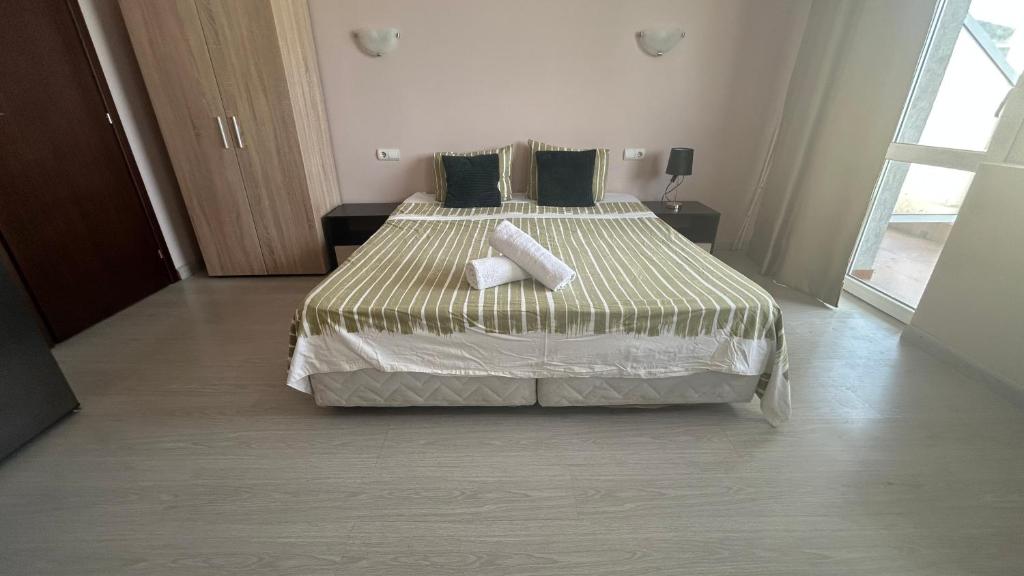 a bedroom with a large bed with two pillows at Корал in Obzor