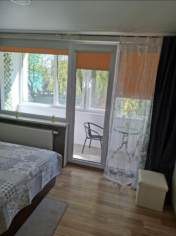 a bedroom with a bed and sliding glass doors with a patio at Amber Stay Birštonas in Birštonas