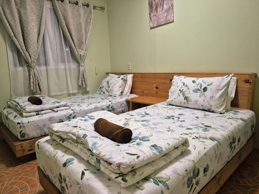 a bedroom with two beds with pillows on them at Sindy's Hostel in Pattaya