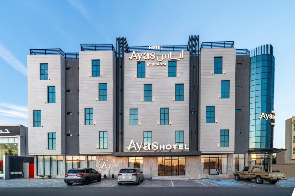 a large building with cars parked in front of it at Ayas Hail Hotel - فندق أياس حائل in Hail