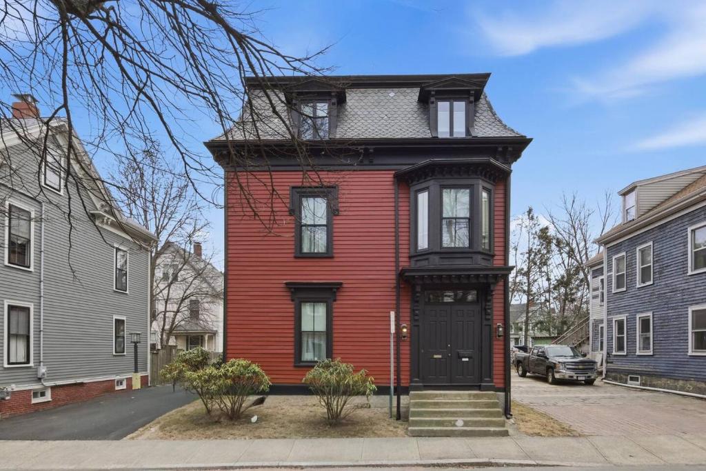 a red house with a black door on a street at Historic home on Salem Neck in Salem