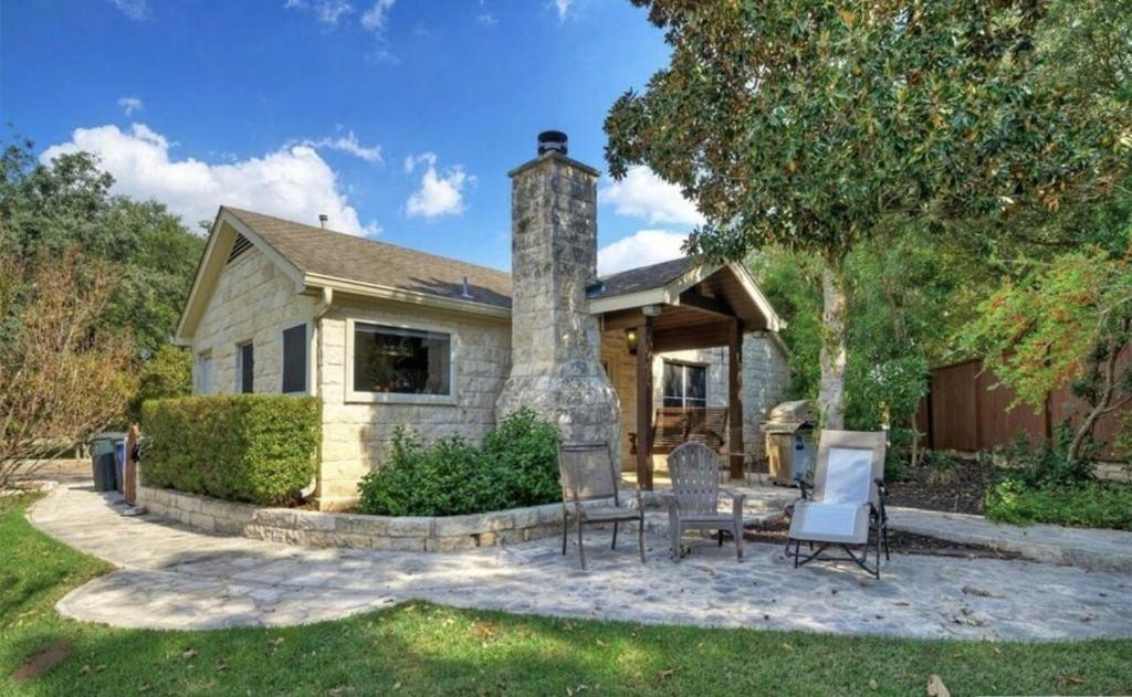 a house with two chairs and a stone chimney at Buda Casita in Buda