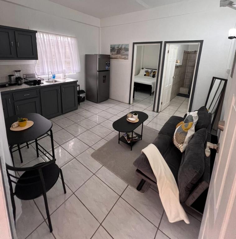 a kitchen and a living room with a couch and a table at Cozy Endz in Castries