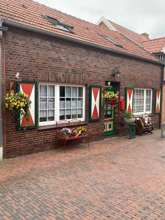 a brick building with windows and flowers on it at Ferienwohnung am Siel in Ditzum