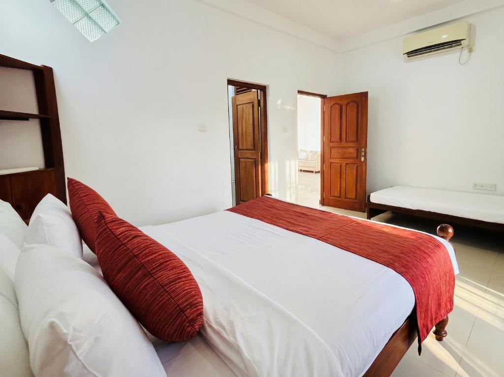 a bedroom with a bed with a red blanket on it at Villa Dream D in Hikkaduwa