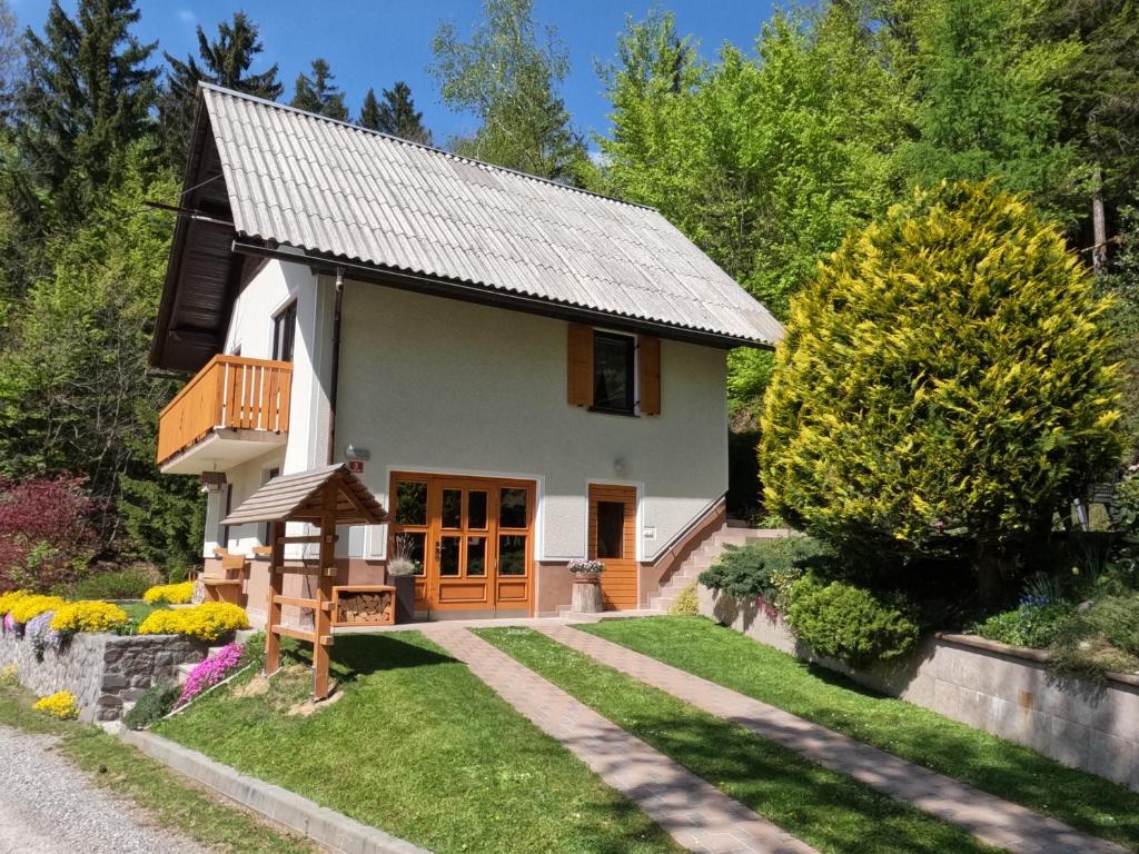 a small white house with a porch at Holiday Home Forest Peace, Lavrovec in Hlevni Vrh