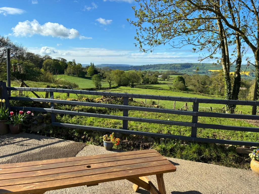 a wooden bench sitting next to a fence at Hyssington Heights in Hyssington